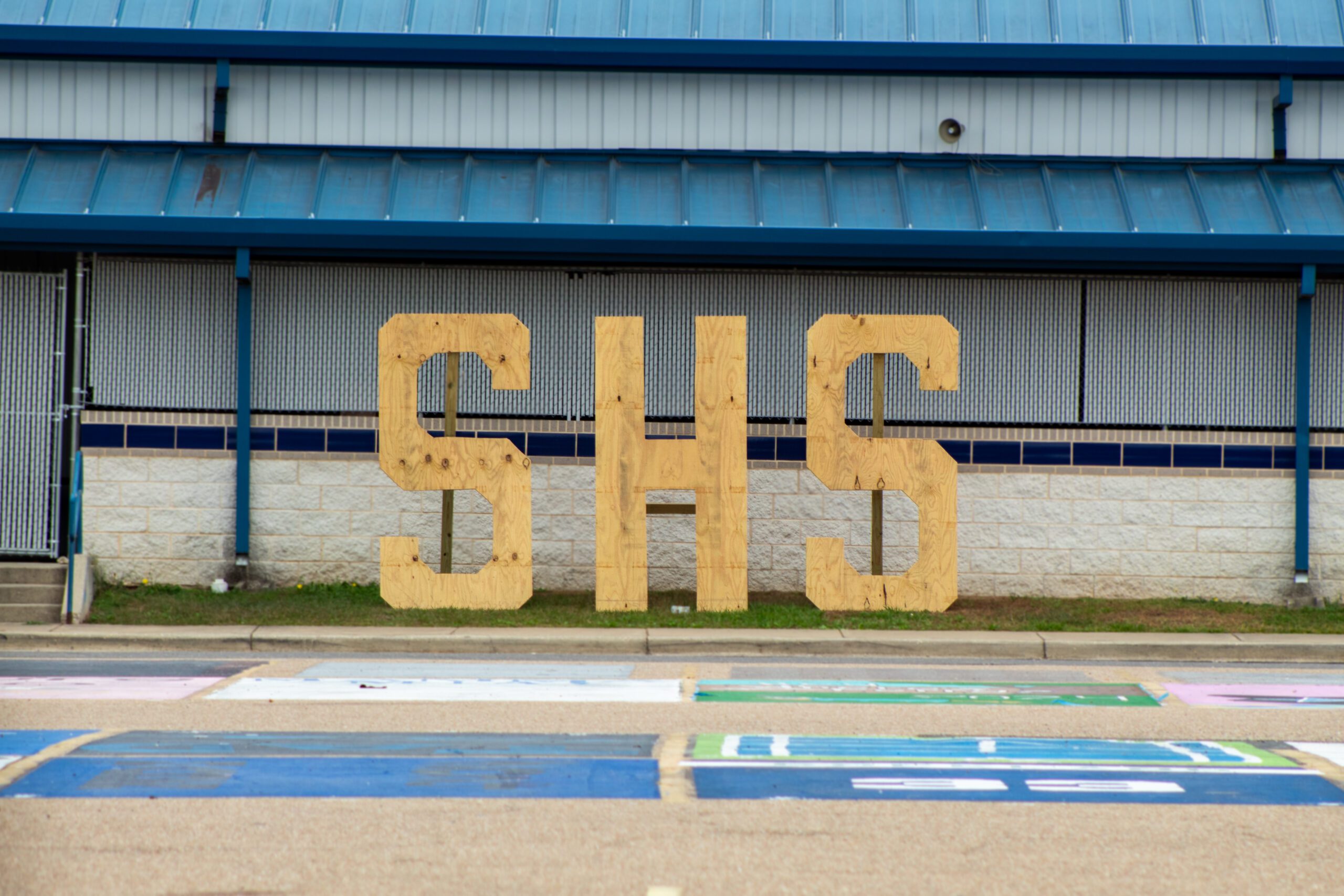 Large wooden letters SHS in front of high school